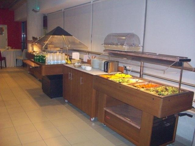 Self-service buffet counter with salads, hot dishes, and drinks arranged on wooden tables