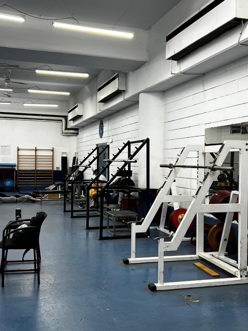 Gym area with lifting equipment and racks used for athletic workout and coaching sessions
