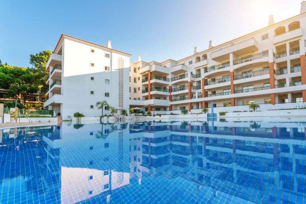 Outdoor swimming pool beside a hotel building.