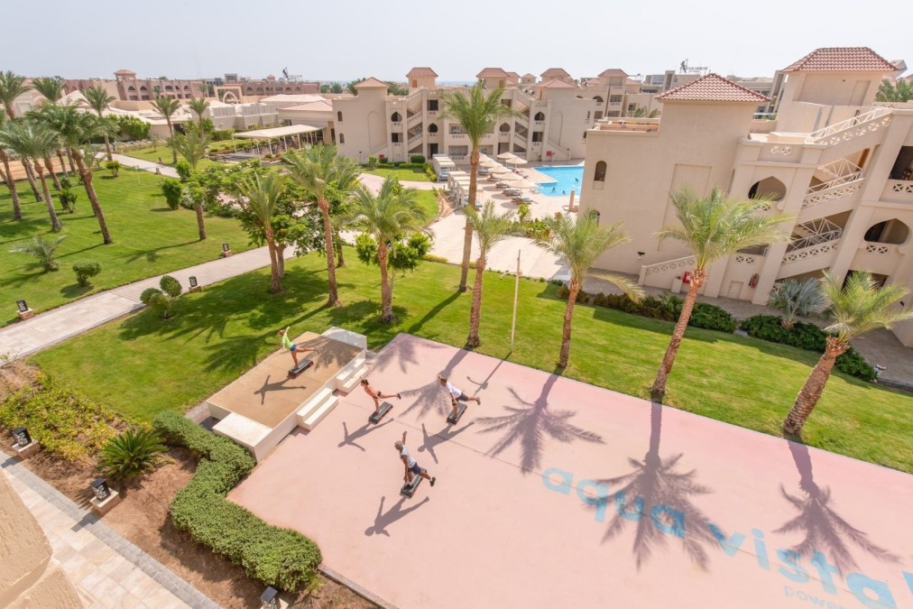 Aerial view of resort gardens with athletes training on outdoor court