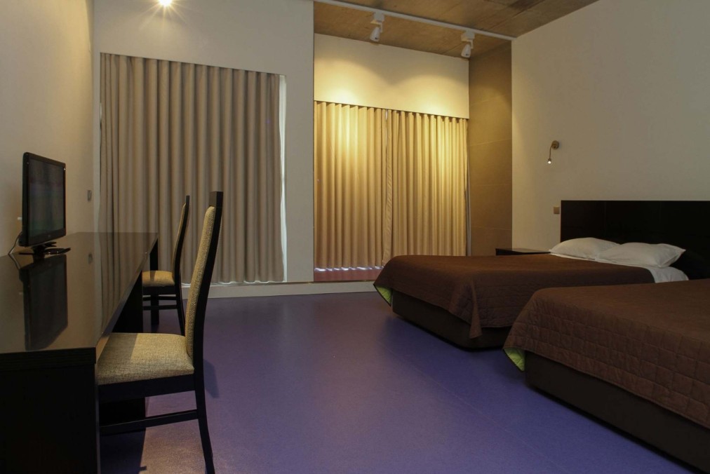 Twin room with work desk and wall-mounted TV