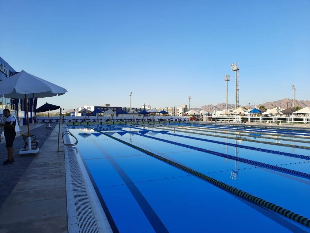 50m outdoor pool with lane lines and floodlights