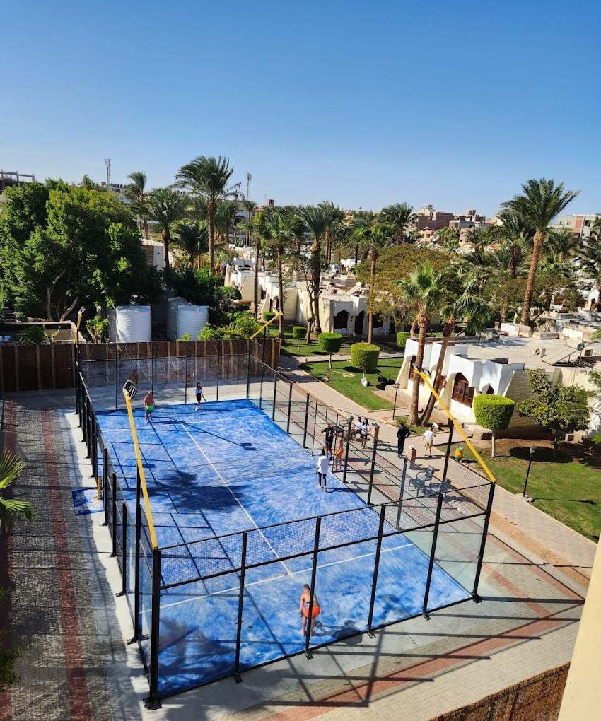 Elevated view of an outdoor padel court in the resort grounds.
