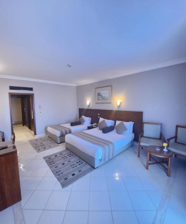 Spacious room with double bed, single bed, and seating area.