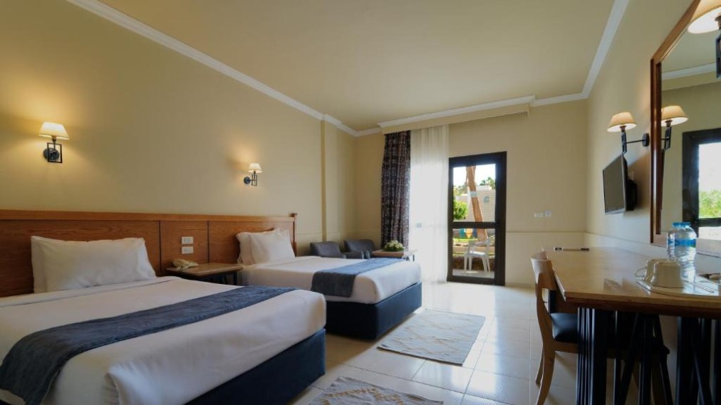 Twin room with two single beds, desk, TV, and patio door.