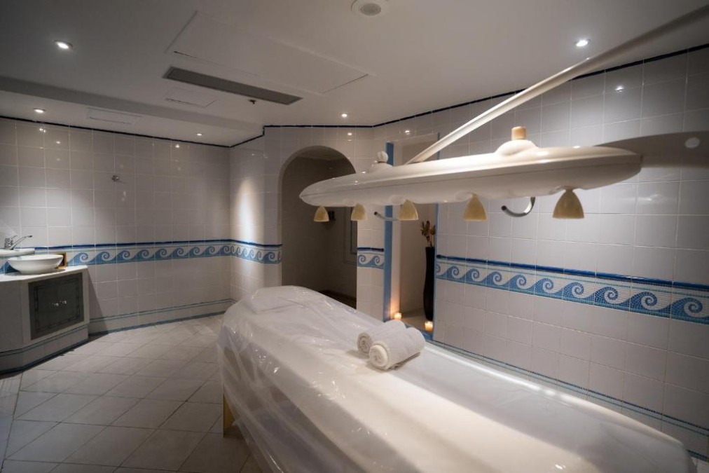 Spa treatment room with massage table and heat lamp for athlete recovery during training camp