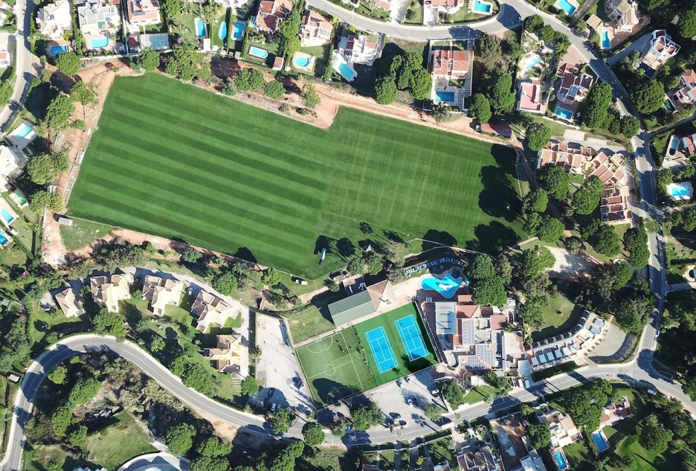 Aerial view of the complex with full-size football pitch and adjacent courts.