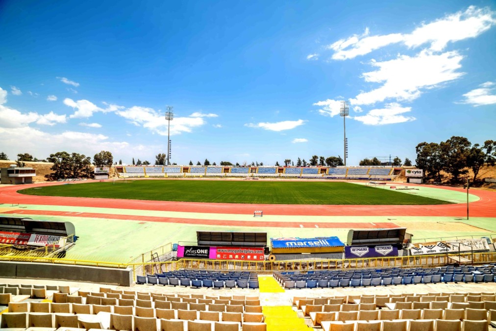 Outdoor stadium with grass field, running track and spectator stands.