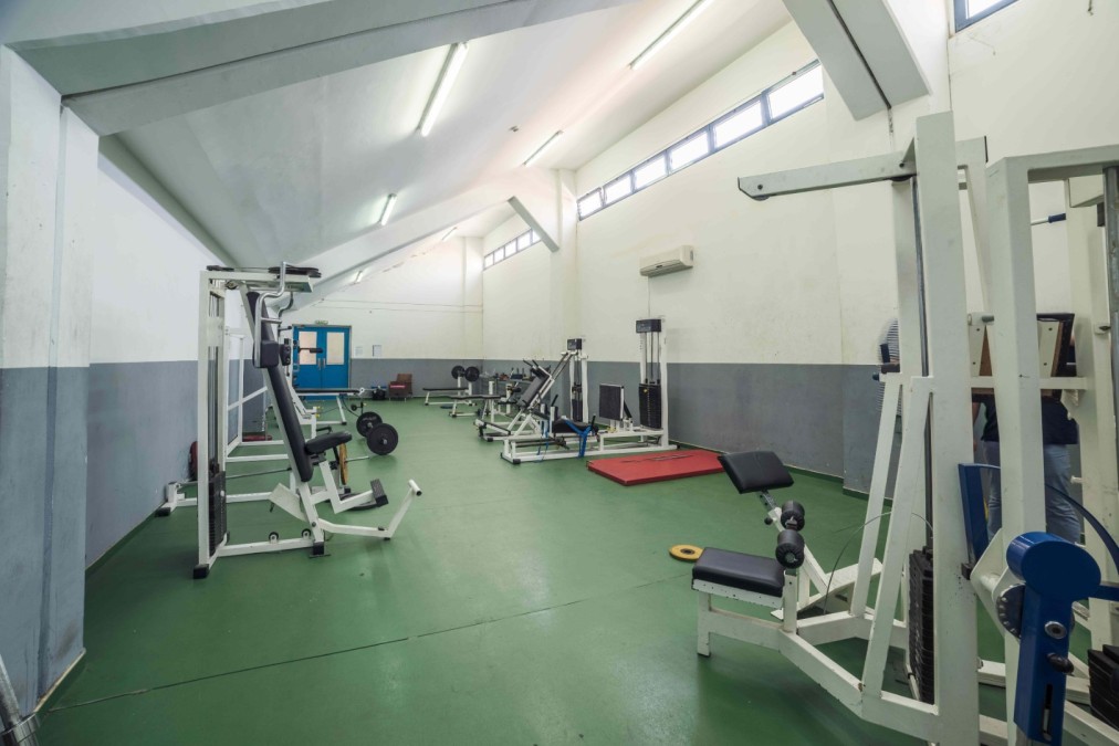 Fitness room with strength machines, benches and weights.