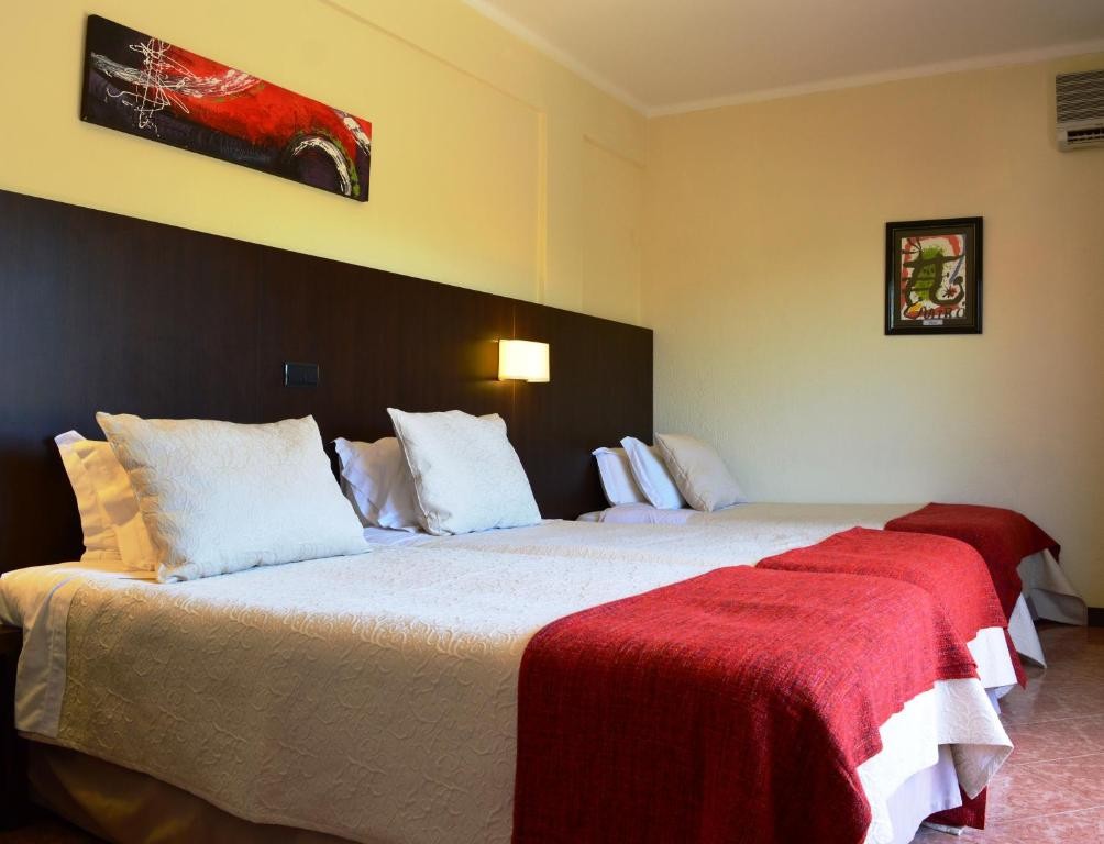 Triple room with three single beds, wall art and bedside lighting.