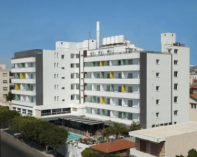 Exterior view of the hotel building with balconies, pool area and surrounding streets.