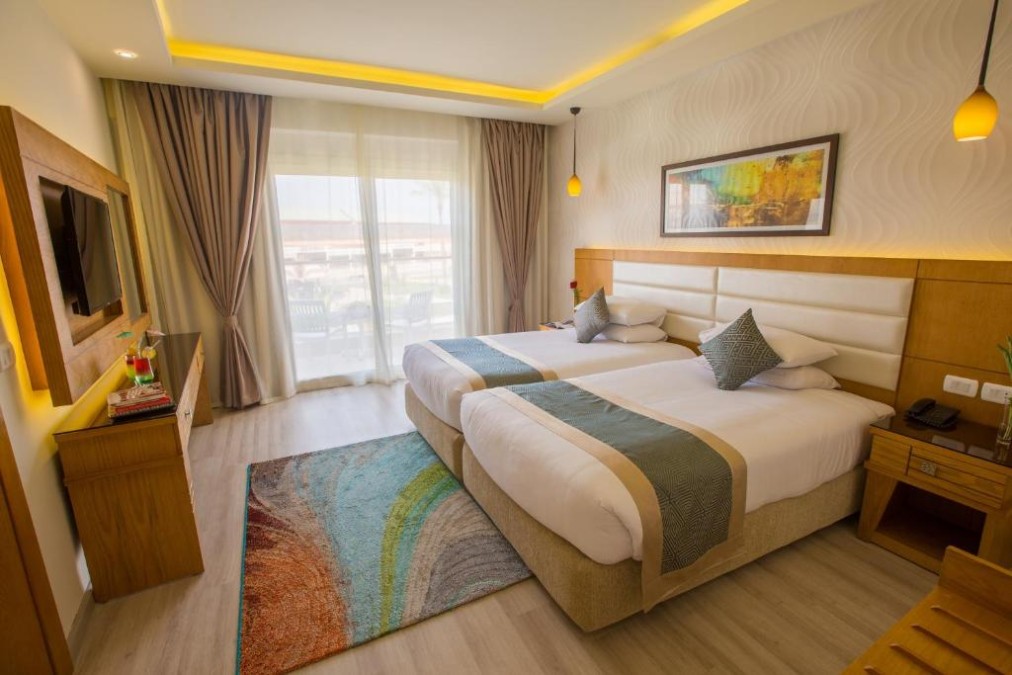Spacious twin room with two single beds and balcony access, ideal for rest between training sessions.