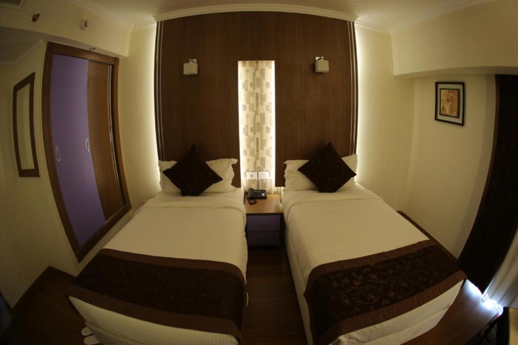 Twin room with two single beds, shared nightstand, and wardrobe.