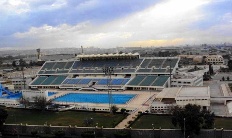 Aerial view of a swimming stadium with grandstands and an outdoor competition pool.