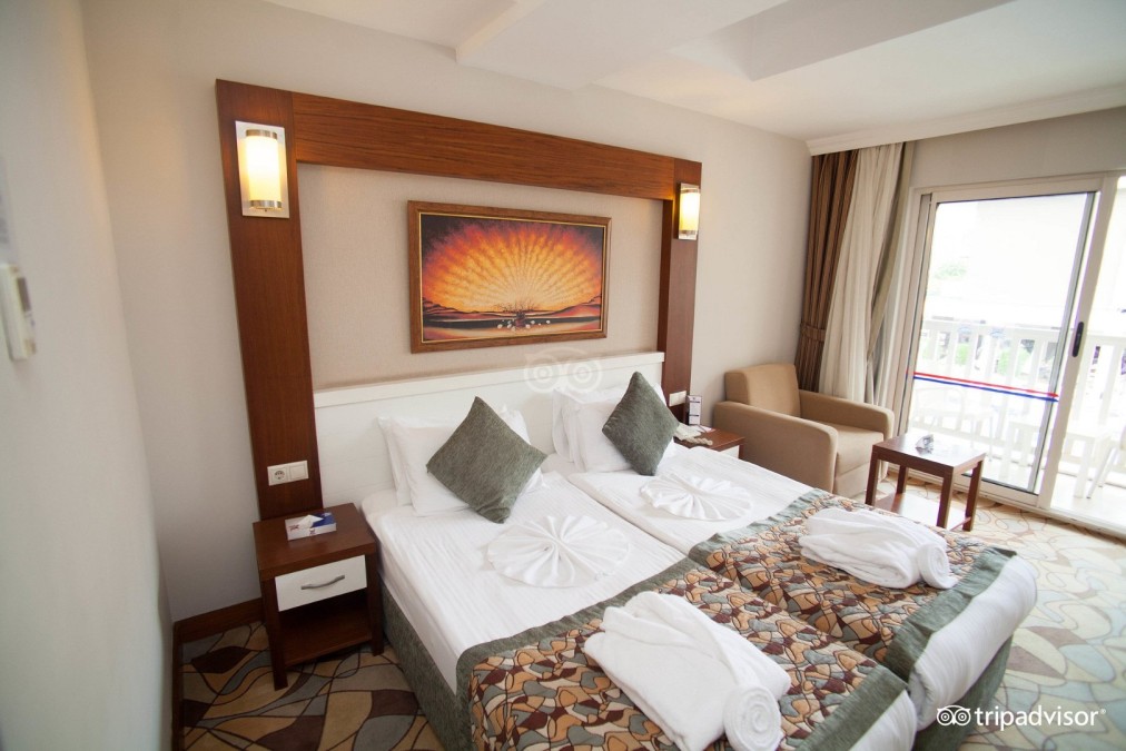 Twin room with balcony doors, bedside tables and seating corner.