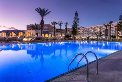 Evening view of the outdoor pool and hotel exterior.