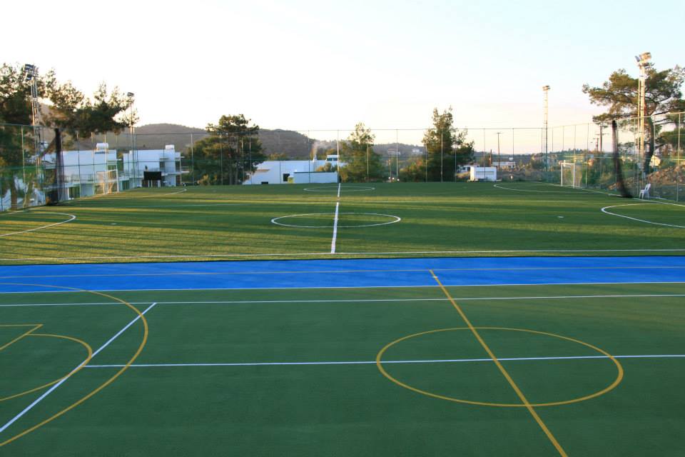 Outdoor multi-purpose sports field with green and blue surfaces for football or basketball