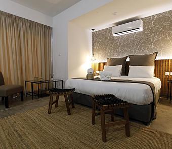 Bedroom with double bed, earthy decor, and soft lighting creating a calm atmosphere