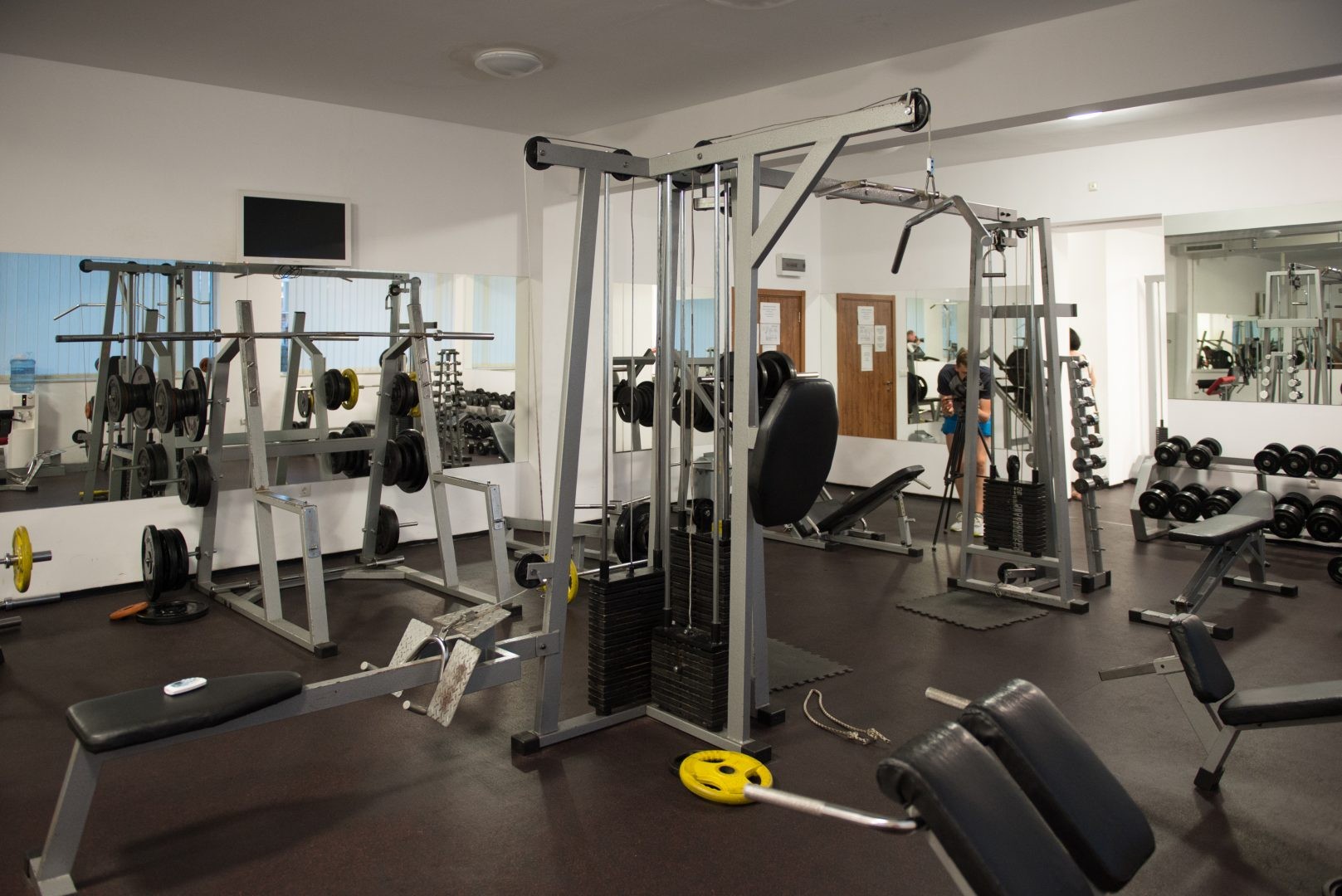 Salle de gym avec machines à câbles, bancs et poids libres utilisés pour les entraînements de musculation en stage