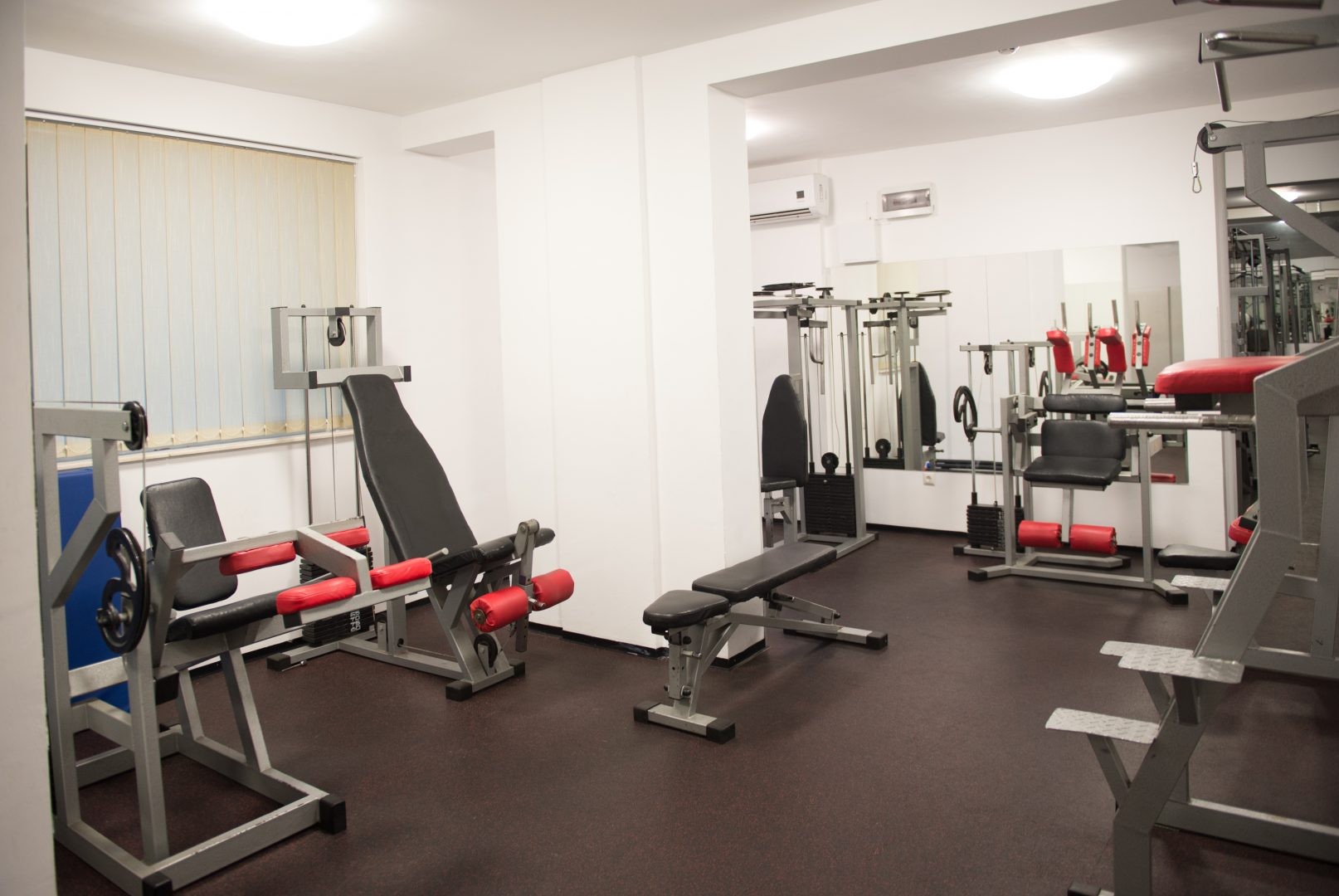 Salle de gym compacte avec bancs et appareils de résistance pour des séances d'entraînement ciblées