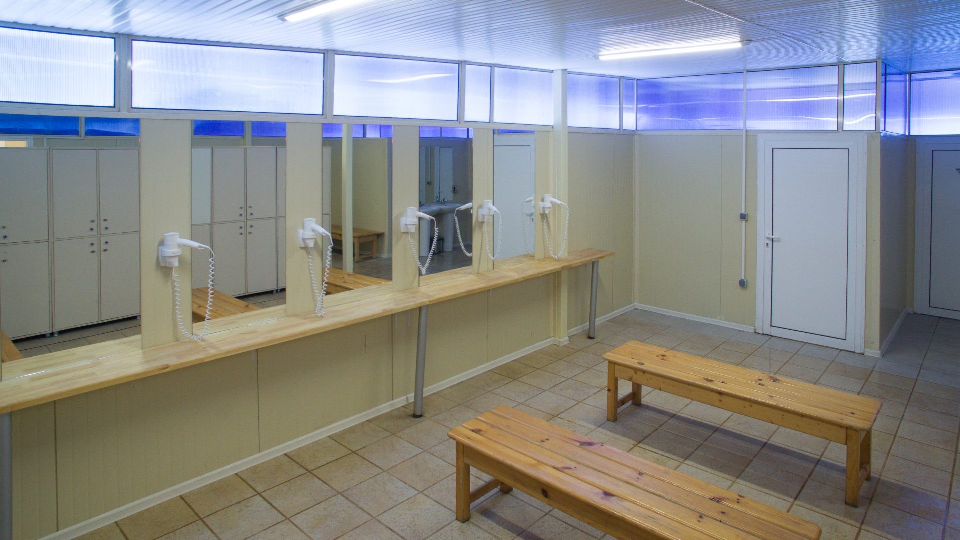 Vestiaire avec bancs, miroirs, lavabos et sèche-cheveux pour les athlètes pendant le stage d'entraînement