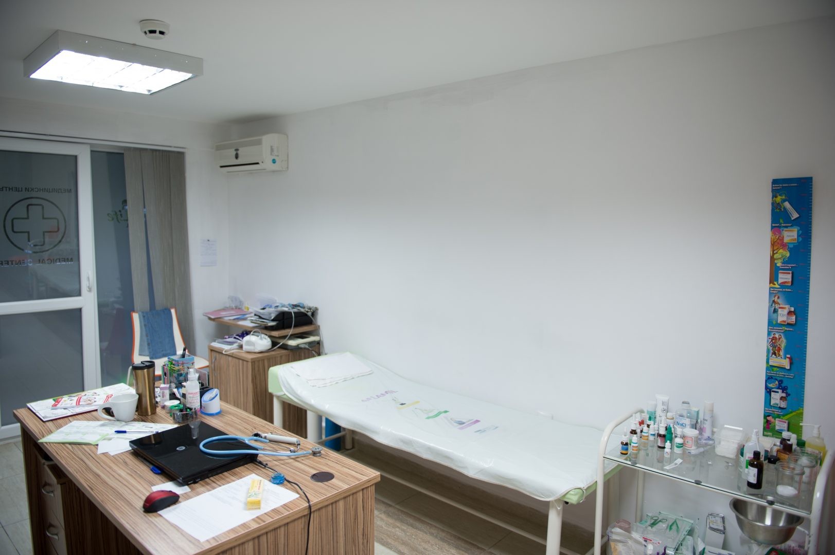 Salle de soins médicaux avec table d'examen, bureau et fournitures pour les soins aux athlètes pendant le stage d'entraînement
