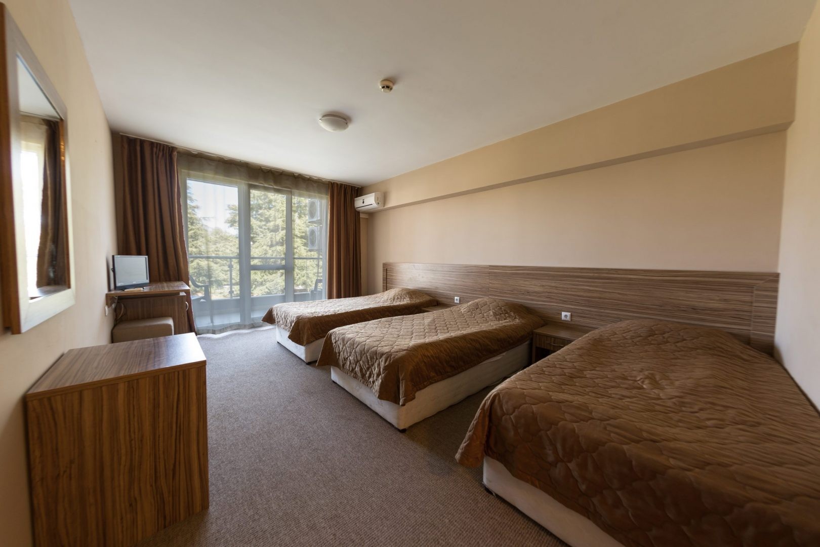 Chambre d'hôtel triple avec bureau et fenêtre, hébergement d'équipe pour les séjours en stage d'entraînement