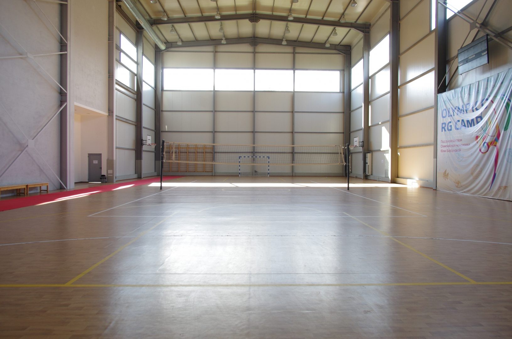 Grande salle de sport intérieure avec marquages au sol et haut plafond, aménagée pour les séances d'entraînement en équipe