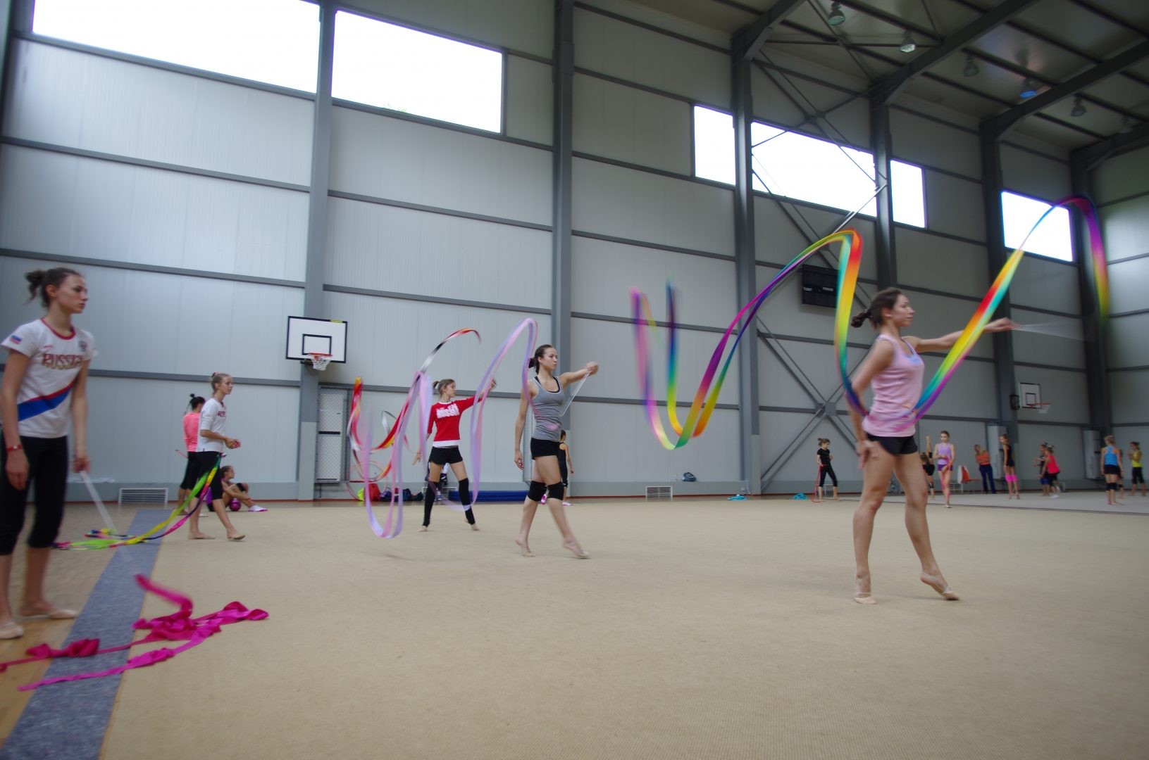 Athlètes pratiquant la gymnastique rythmique avec rubans dans une salle intérieure pendant une séance de stage d'entraînement