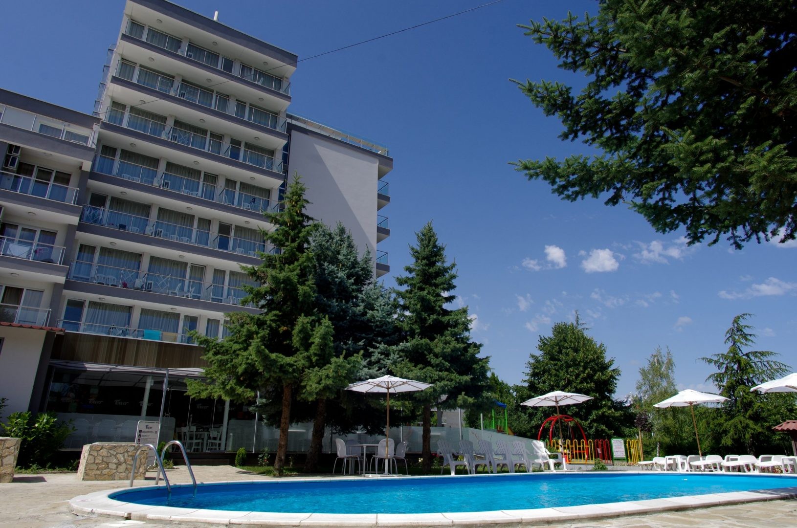 Piscine extérieure d'hôtel à côté d'un bâtiment à plusieurs étages, utilisée pour les séances de récupération pendant le stage d'entraînement