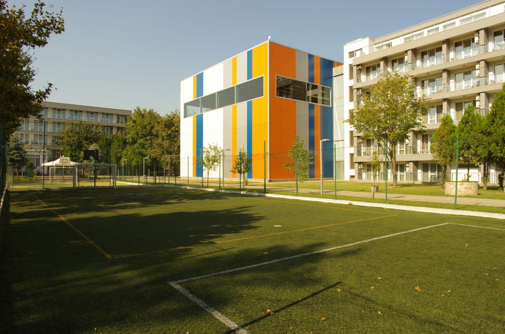 Terrain synthétique extérieur à côté de bâtiments modernes, tracé pour les exercices de football pendant un stage d'entraînement