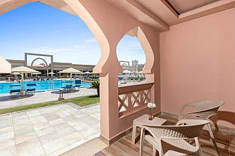 Resort terrace with chairs overlooking swimming pool and umbrellas