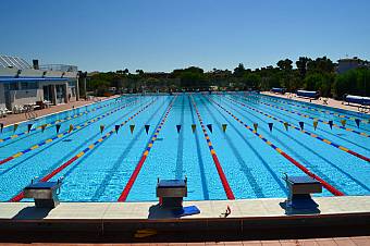 Overhead view of blue swimming pools next to the beach, ideal for swimmer training camps