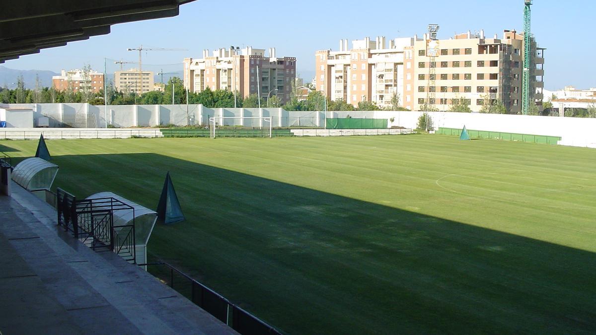 Vue panoramique de la piste d'athlétisme et du terrain intérieur depuis les tribunes du stade.