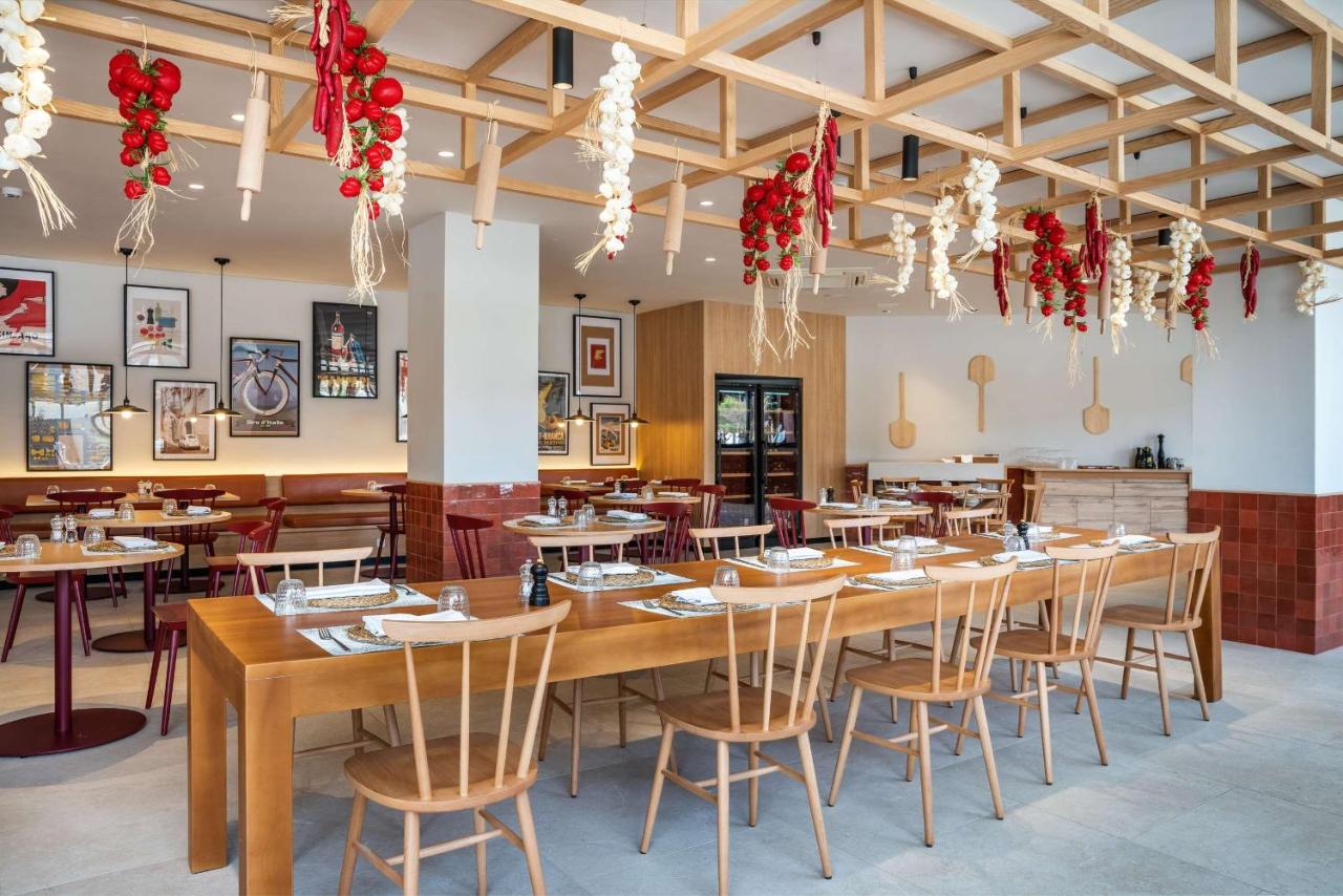 Restaurant mit Gemeinschaftstischen, Holzdekor und hängendem Knoblauch und Tomaten.
