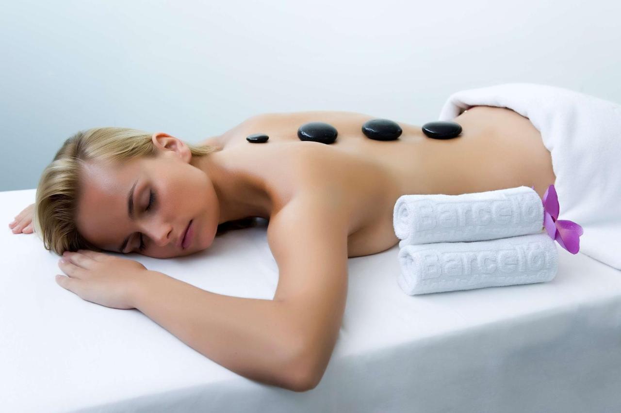 Person bei einer Hot-Stone-Massage auf einer Behandlungsliege.