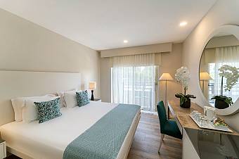 Double guest room with balcony doors, desk and dressing mirror.