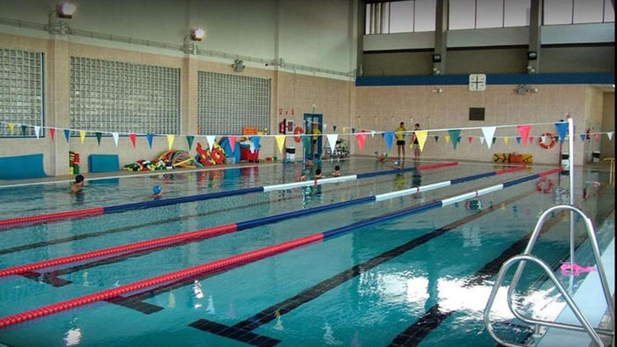 Innenbecken mit markierten Bahnen, Wimpelleine und Schwimmtrainingsmaterial am Beckenrand.
