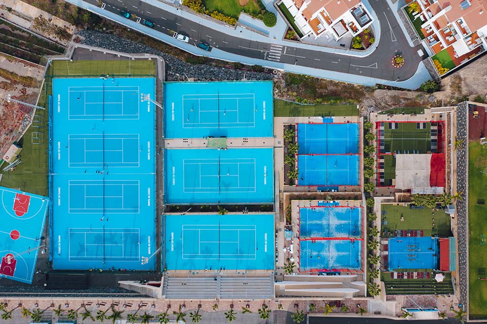 Aerial view of blue tennis and padel courts at the sports venue.
