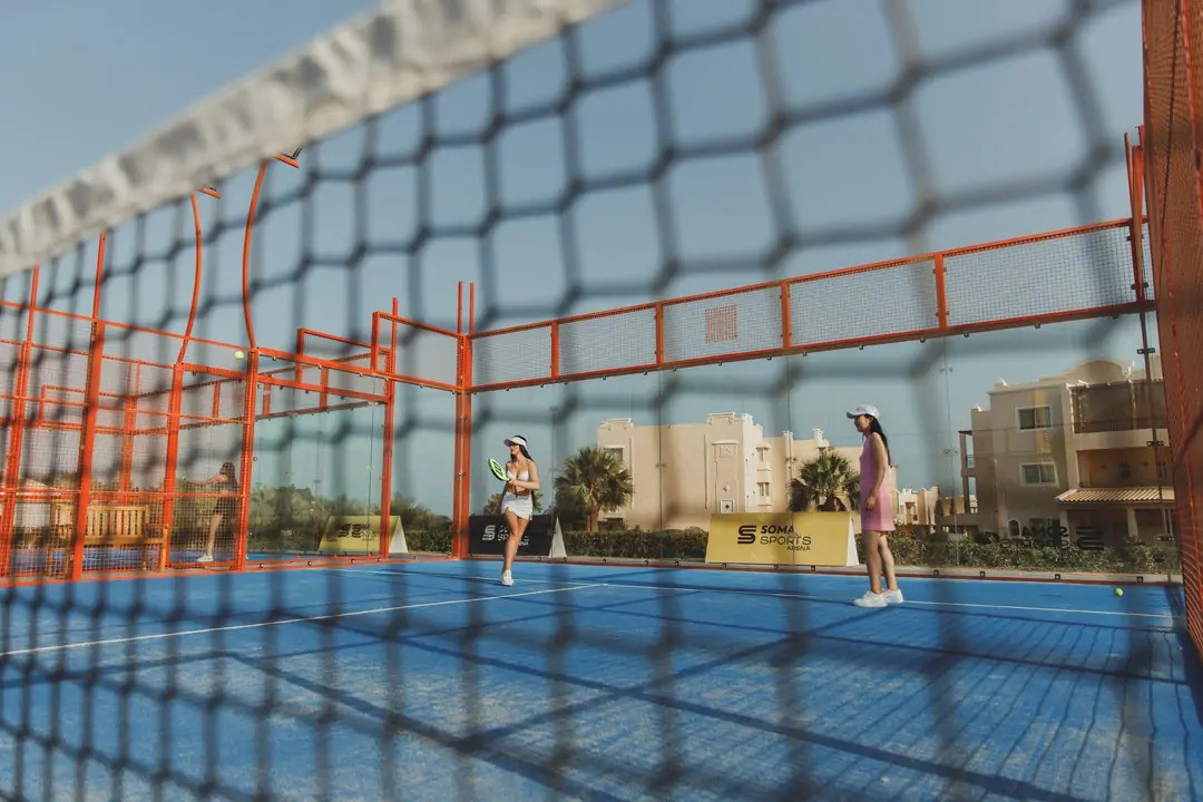 Overhead view of single blue tennis court with shadows cast