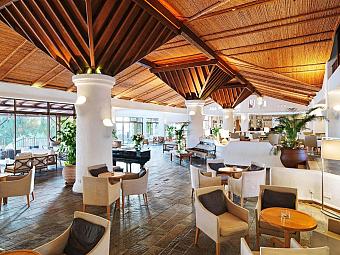 Spacious hotel lounge with wooden ceiling, modern furniture, and natural light near training camp facilities
