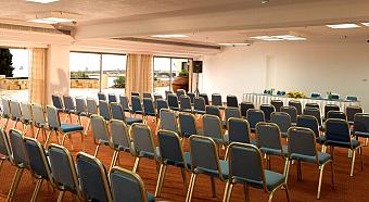 Presentation hall with rows of blue chairs and a front table for team seminars or workshops