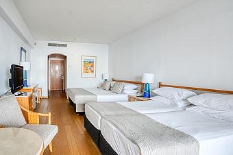 Spacious hotel room with multiple beds and wooden furniture for team accommodations