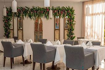 Elegant dining room with white tablecloths, gray chairs, and floral decor for team meals