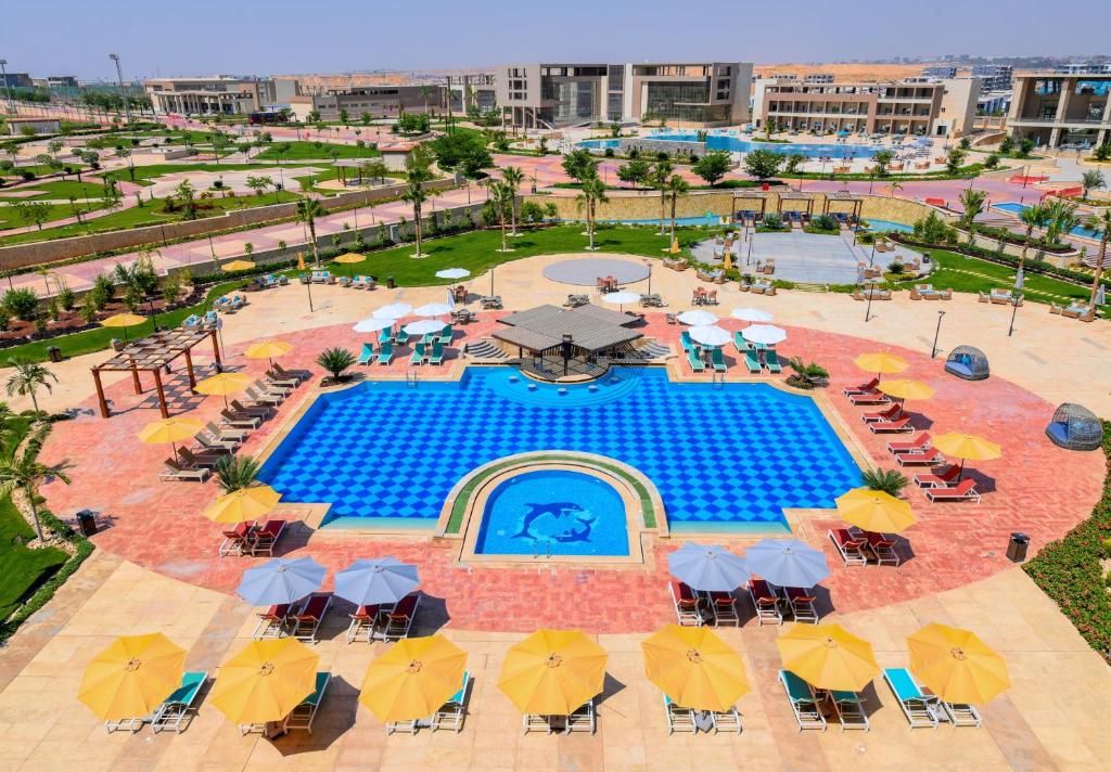 Outdoor pool with dolphin mosaic, surrounded by sun loungers and umbrellas