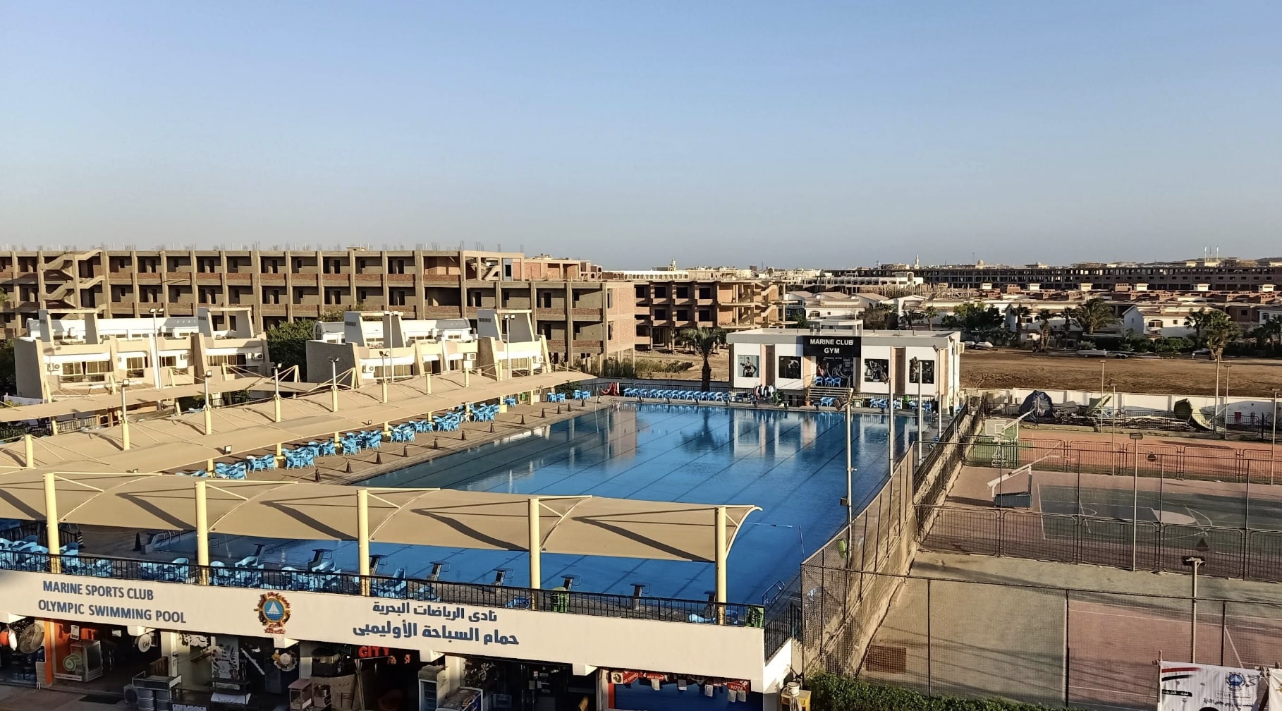 Vue aérienne du complexe Marine Club avec piscine olympique et courts de tennis