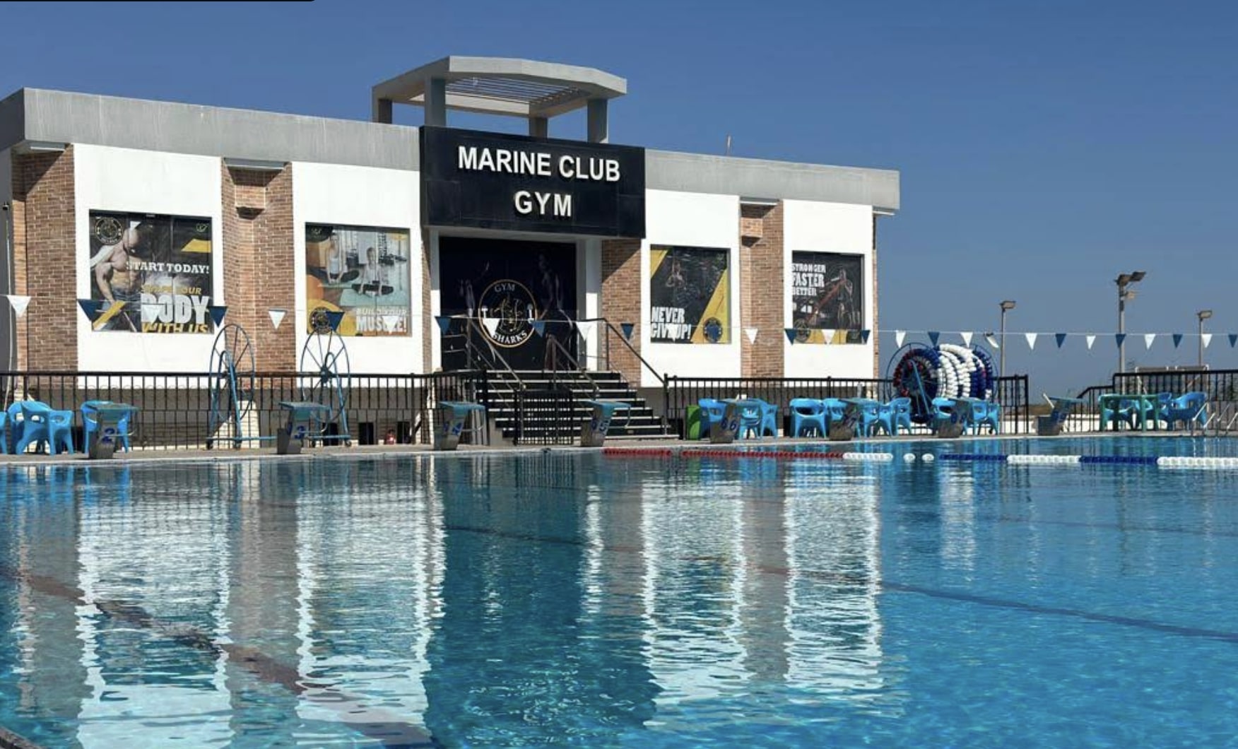 Gros plan du bâtiment Marine Club Gym surplombant la piscine extérieure