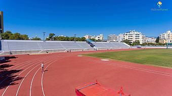 Athletics track with red lanes and empty bleachers prepared for practice sessions
