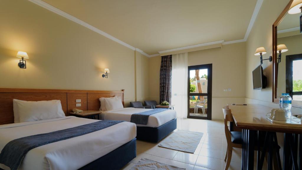 Twin room with two single beds, desk, TV, and patio door.