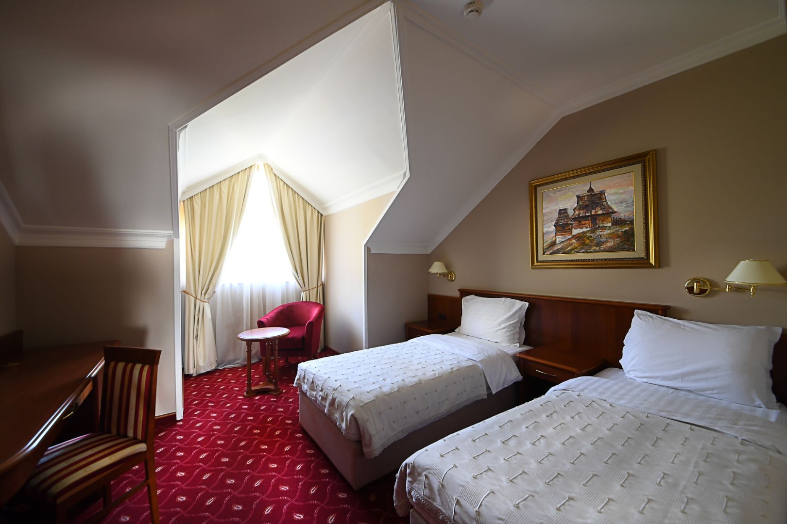 Twin room with two single beds and a small seating area by the window.